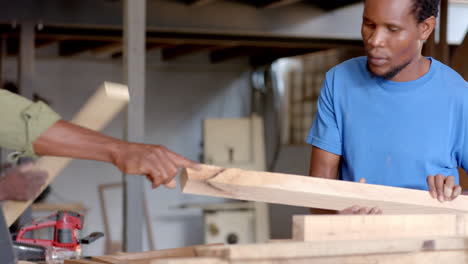 inspecting wooden planks african american coworkers working in carpentry workshop, with power drill