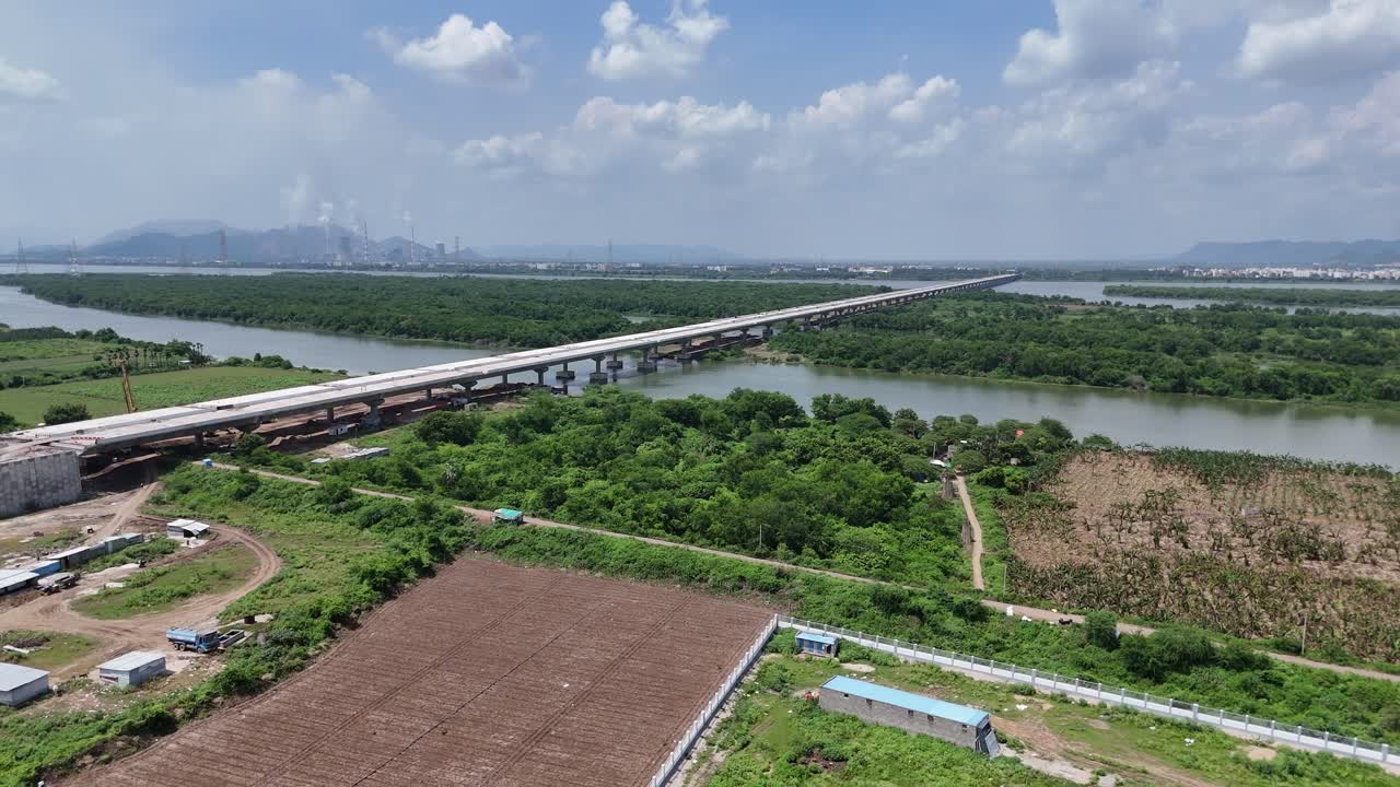 Aerial video of a peaceful highway running through green fields in the Amaravathi region of India.