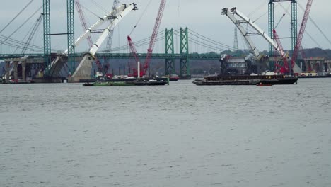 idled construction of i-74 bridge over the mississippi river at quad cities; delays caused by monetary contract disputes, potential design errors, labor shortages and poor weather