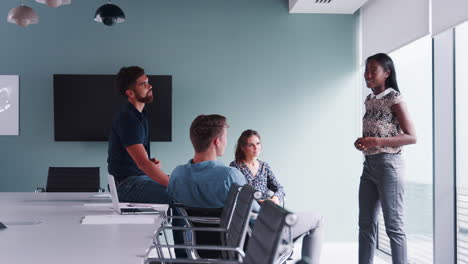 Hombres-Y-Mujeres-De-Negocios-Vestidos-Informalmente-Teniendo-Una-Reunión-Informal-En-Una-Moderna-Sala-De-Juntas-Filmada-En-Cámara-Lenta