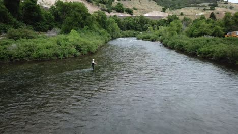 disparo de drones acercándose a un hombre pescando con mosca en el río provo en las montañas de utah-1