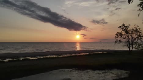 Amanecer-Sobre-El-Lago-Huron-En-Michigan-Con-árbol-Y-Playa