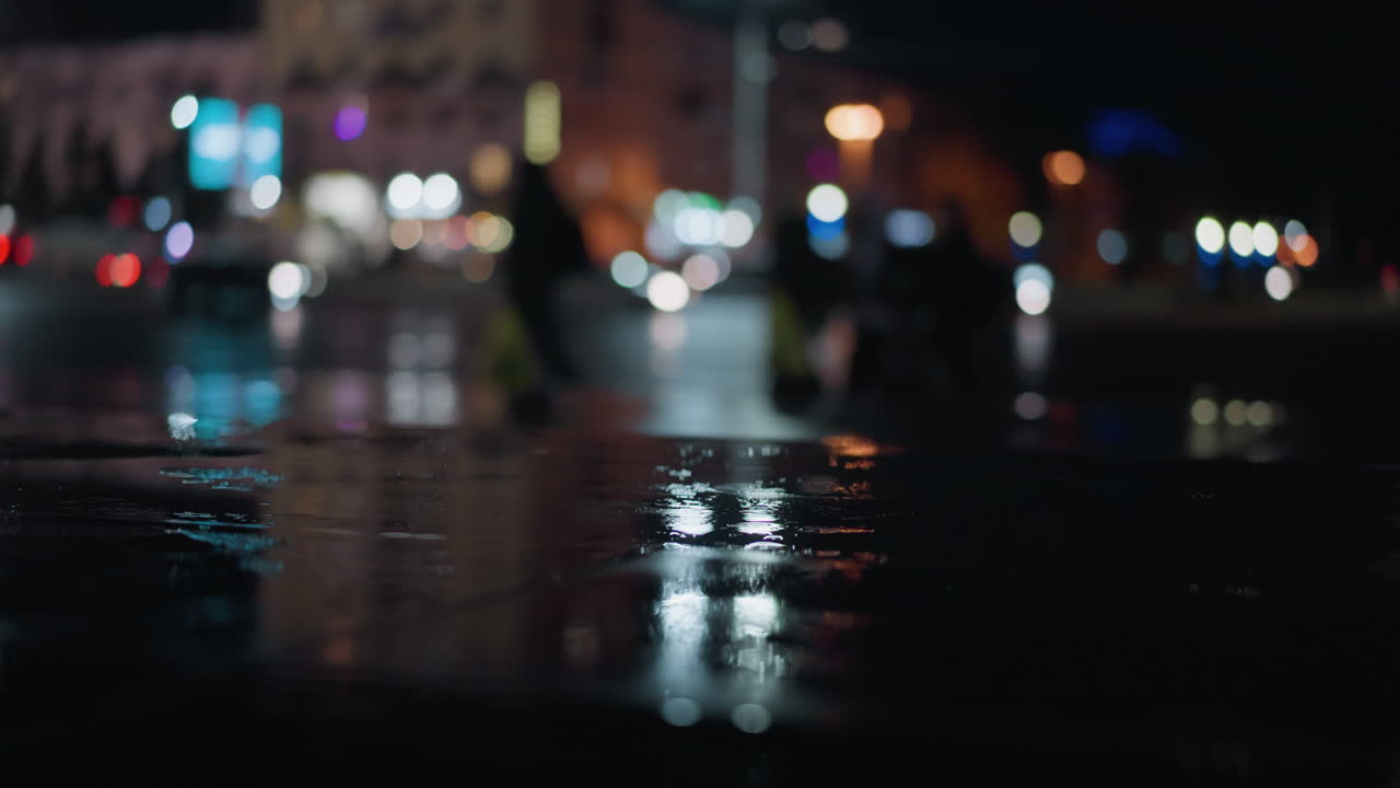 Blurred view of cars passing with headlights on a wet city street at ...