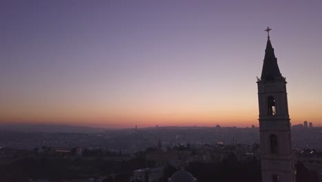 aerial footage of a large church tower in old city jerusalem during sunset