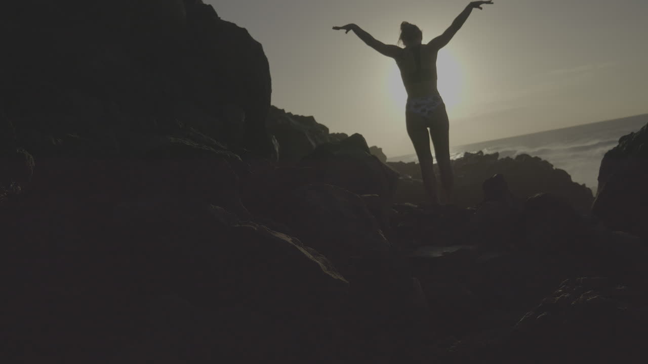 Woman on Rocks at Sunrise