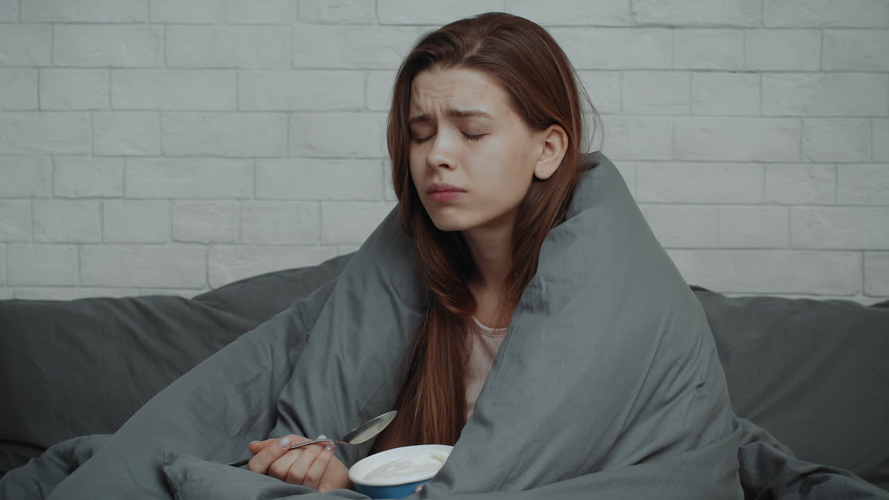 Donna malata che mangia il gelato a letto