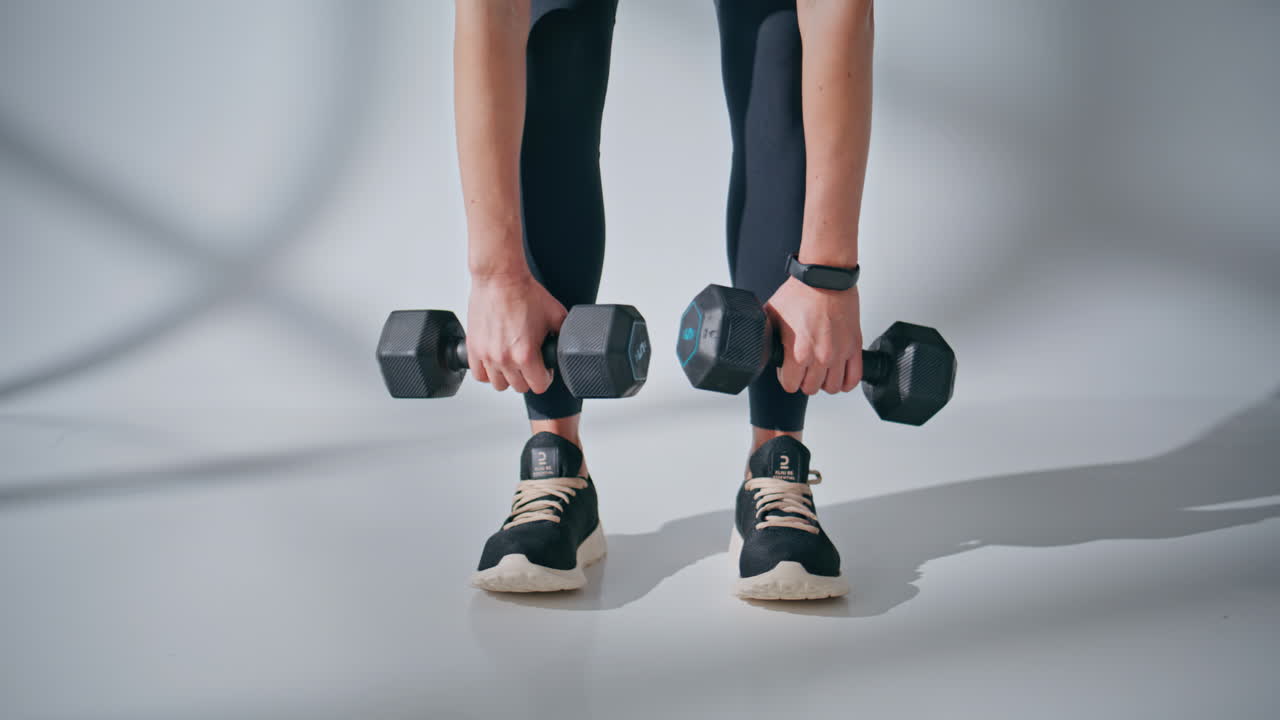 Trainer body doing dumbbells workout gym closeup. Strong athletic lady training
