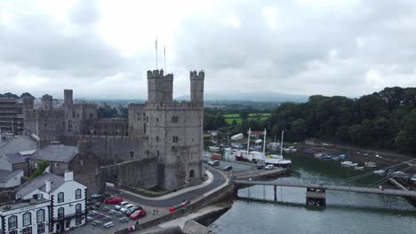 ancient caernarfon castle welsh harbour town aerial view medieval waterfront landmark rising orbit right