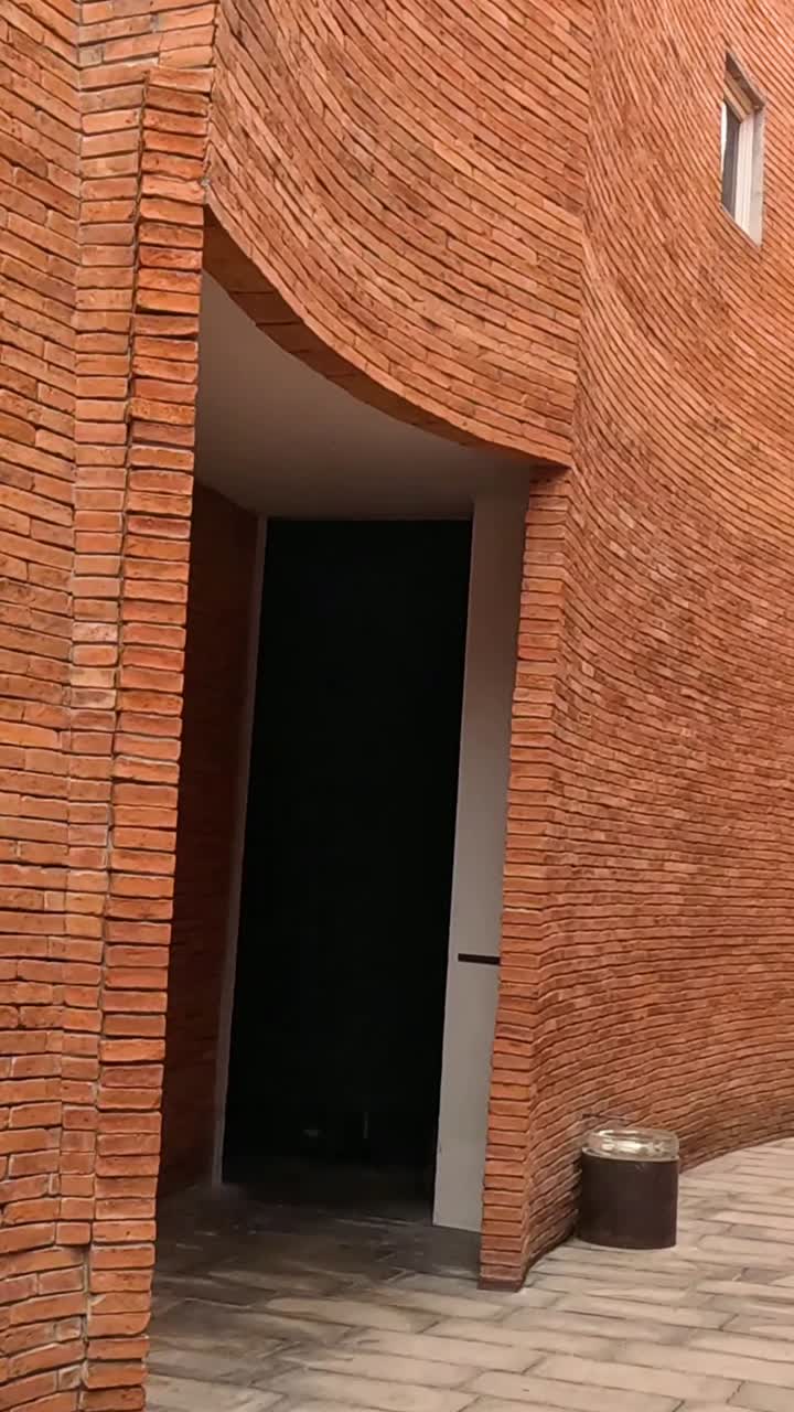 카메라는 구부러진 벽돌 복도를 통해 움직입니다.