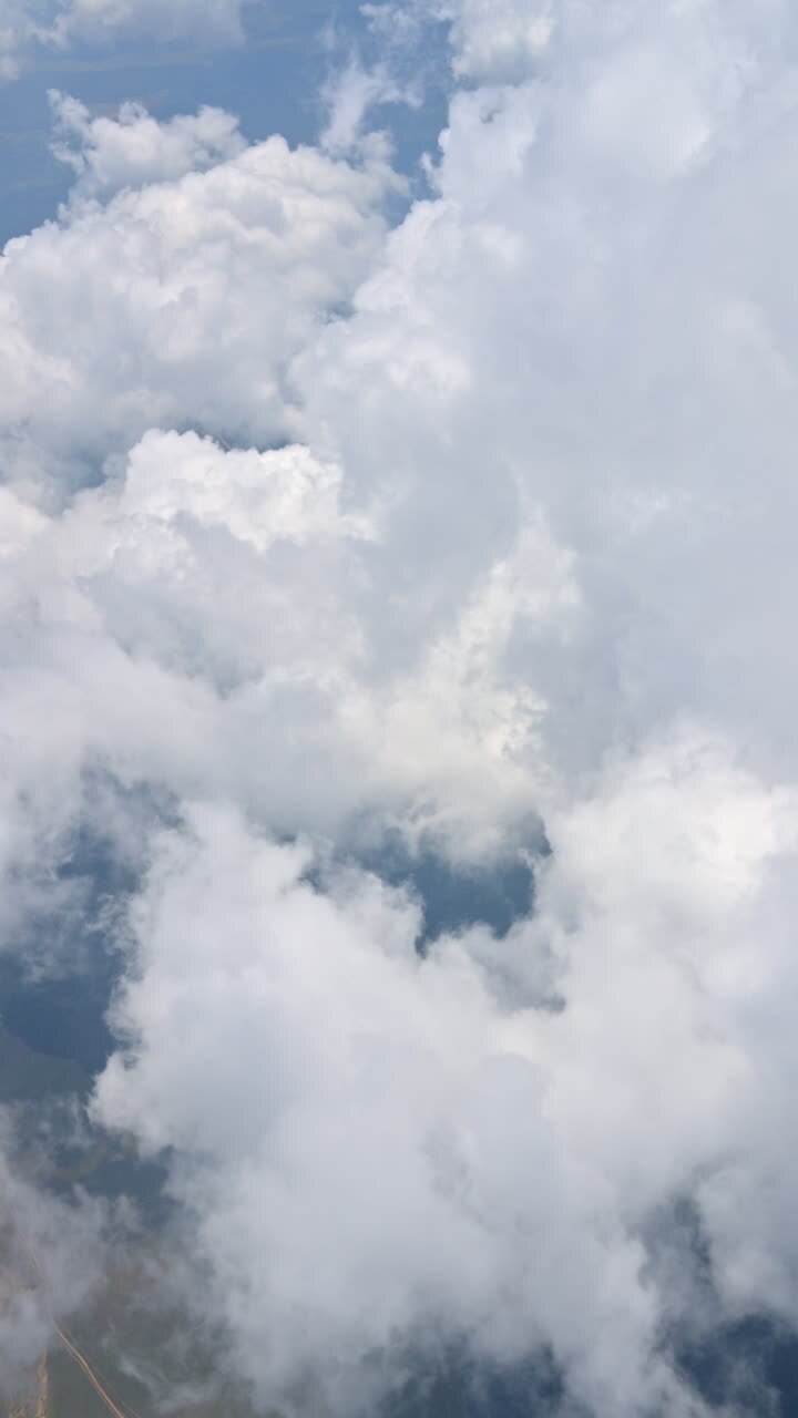 View of the clouds from an airplane window. Vertical