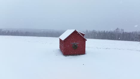 Lovely-little-cabin-surround-by-fresh-winter-snowfall-aerial-shot