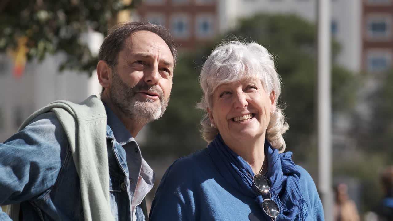Happy mature man and woman talking during walk