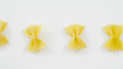 row of bow tie pasta on white background