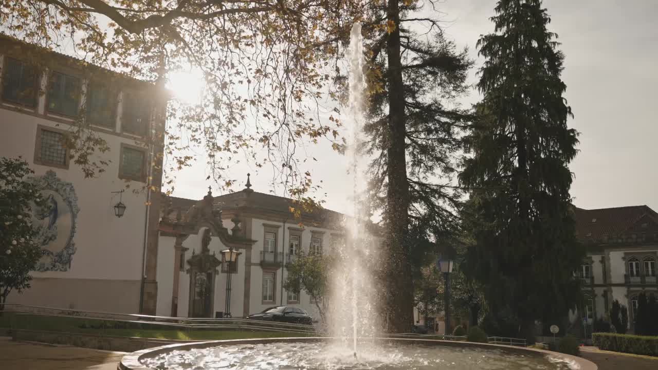 fuente iluminada por el sol que se alza ante el monasterio de São José do Carmo en Guimarães