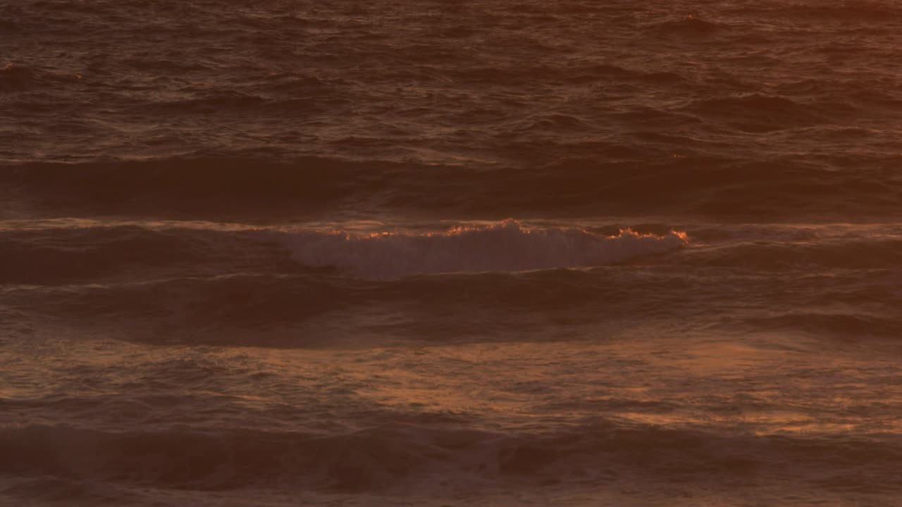 오렌지색 해가 지는 것을 반영하는 바다의 물결