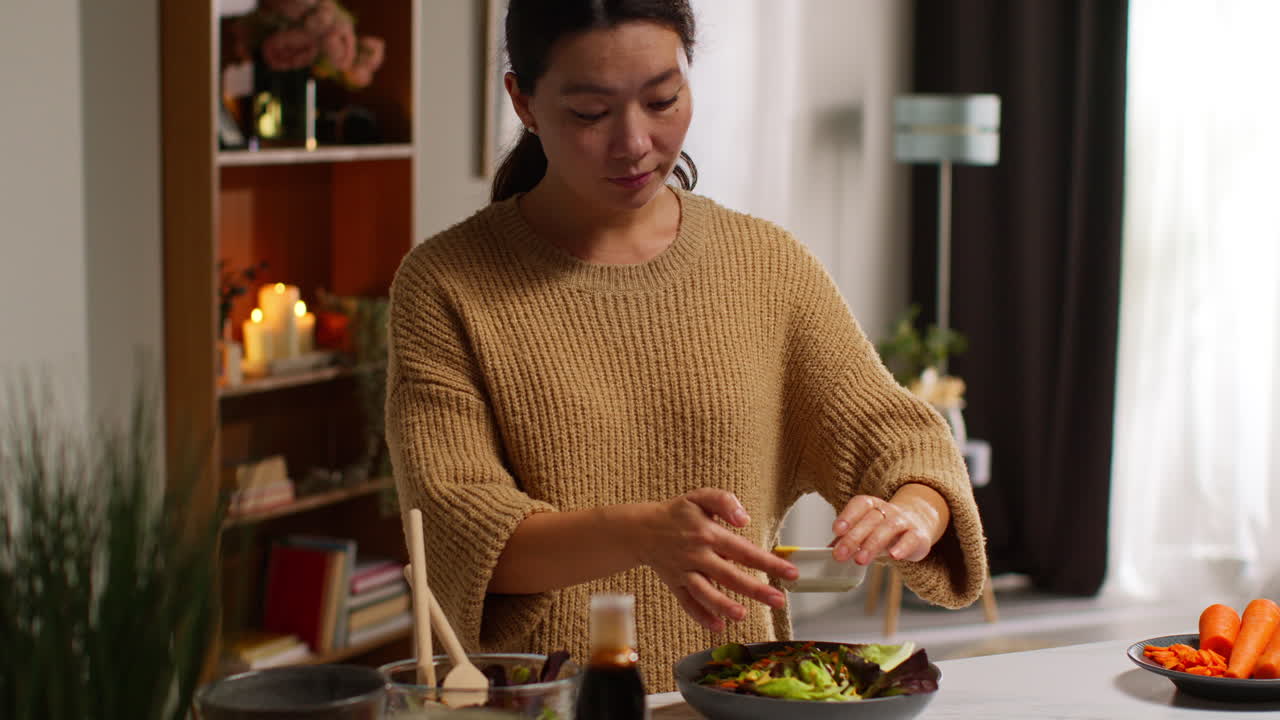 가정에서 부에서 여성이 건강한 채식주의자 또는 채식주의자의 식사를 준비하고 러드 잎의 그에 드레싱을 부어