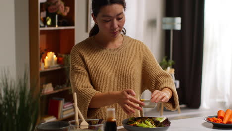 가정에서 부에서 여성이 건강한 채식주의자 또는 채식주의자의 식사를 준비하고 러드 잎의 그에 드레싱을 부어