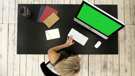beautiful young woman talking on smart phone, using computer. green screen mock-up display