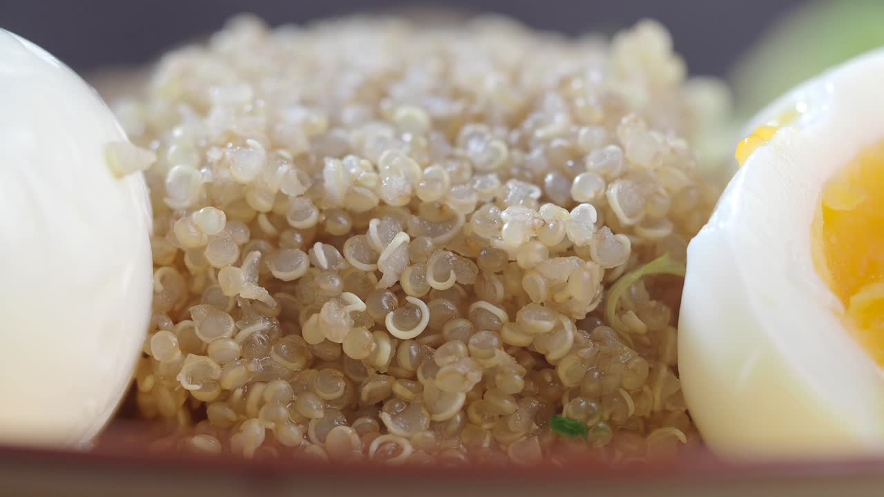 Nærbilde av kokt quinoa og et skivet kokt egg.