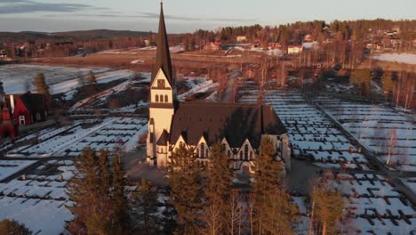 areal side view of majestic scandinavian church-cemetery in vindeln, sweden. shoot on a cold snowy morning.