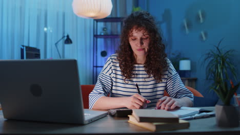 joven mujer de negocios que trabaja con computadora portátil y documentos de planificación de gastos presupuesto en casa