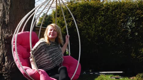 attractive woman relaxing in garden chair swing wide 4k slow motion