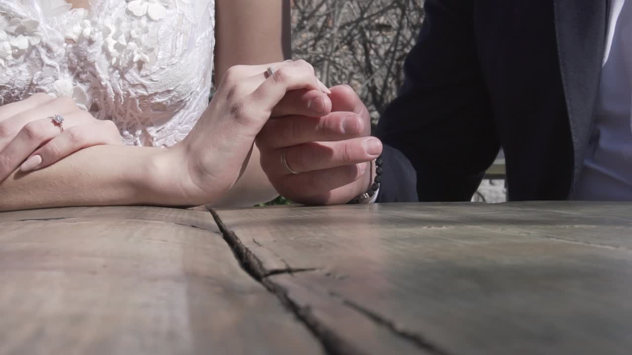 신혼 부부는 손가락에 반지를 끼고 손을 애무합니다.