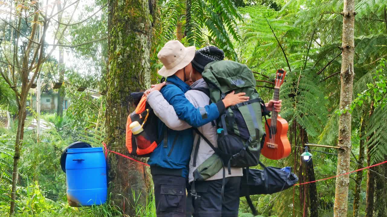 Joyful group of friends embracing warmly in lush forest setting during hike together