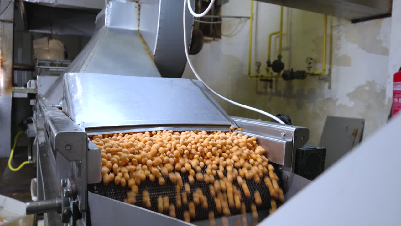 Moving shot of a beer nuts falling of a rail