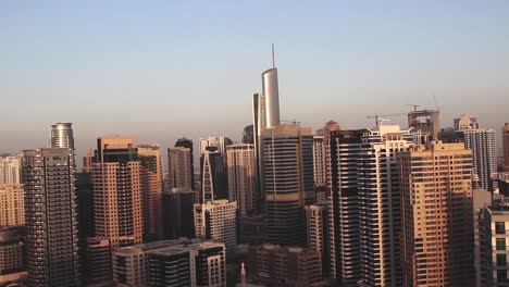 poklatkowy zachód słońca w drapaczach chmur w dubaju, burj khalifa w tle, czyste niebo, statyczne ujęcie