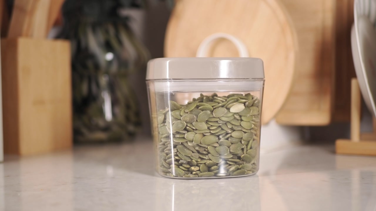 Close-up of Pumpkin Seeds in a Container on a Kitchen Counter