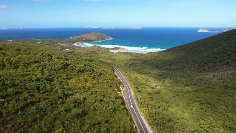 4k drone video following a white camper van driving on the road through wilsons promontory in victoria, australia