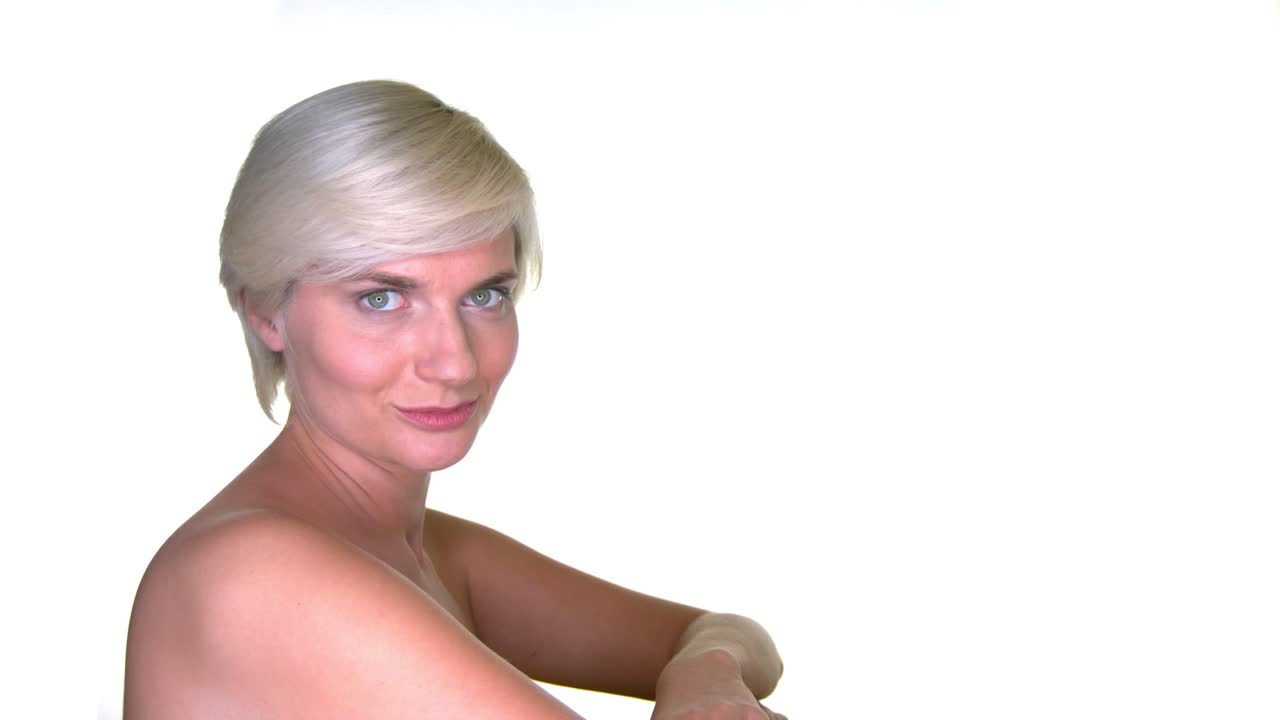 una mujer de pelo corto mirando a la cámara desde un lado con sus hermosos ojos bien abiertos