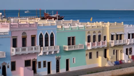 colorful pastel buildings and boats along a tranquil waterfront