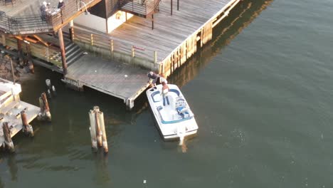 Aerial-Of-Tourist-Getting-Off-The-Power-Boat-At-The-Wooden-Jetty-In-New-Orleans,-Louisiana-USA