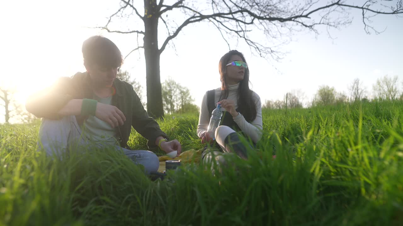 Couple enjoying a picnic in a park at sunset