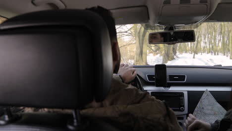 Caucasian-couple-in-love-driving-through-snowed-forest.