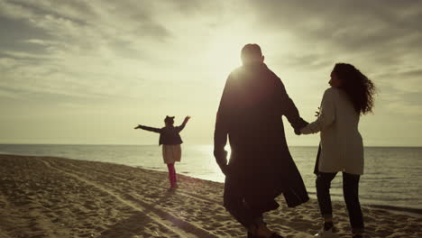 Mirada-Familiar-En-La-Playa-Al-Atardecer-En-Un-Hermoso-Paseo-Por-La-Naturaleza.-El-Grupo-De-Personas-Disfruta-De-La-Costa-Del-Océano.