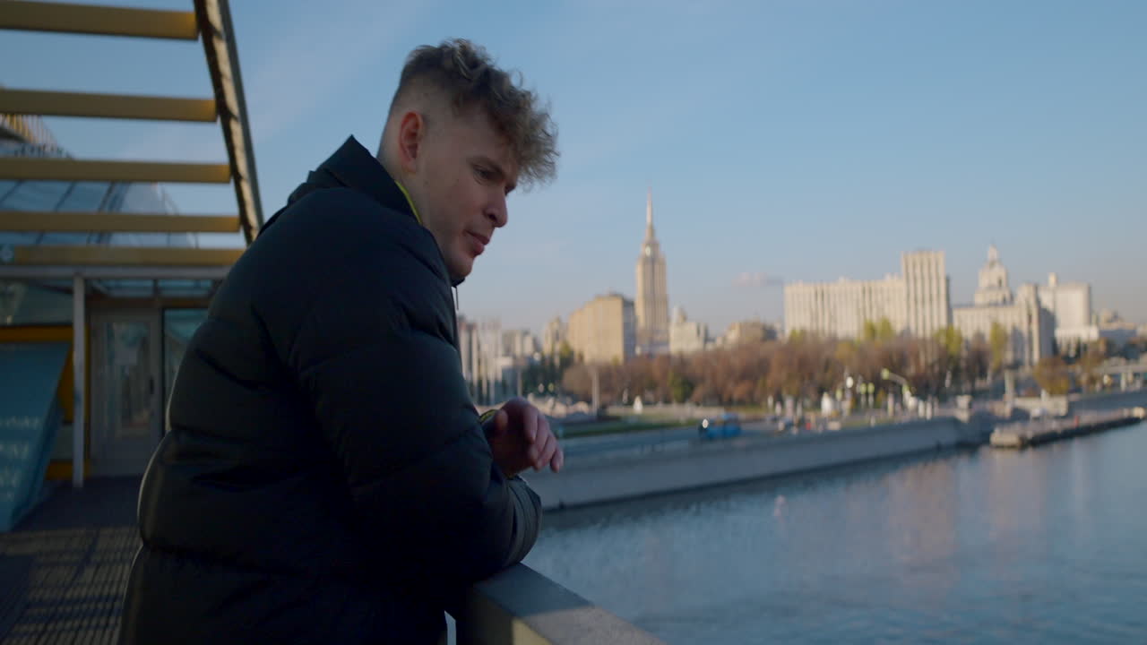 Man Contemplating Cityscape from Bridge