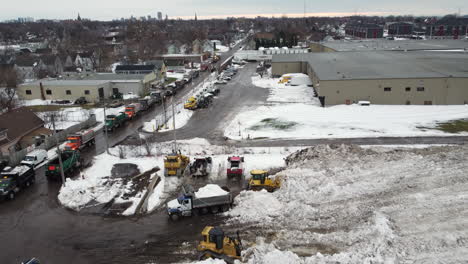 Aerial-view-above-convoy-of-bulldozers-and-hydraulic-vehicles-cleaning-heavy-snowstorm-disaster-from-Buffalo-neighbourhood-streets