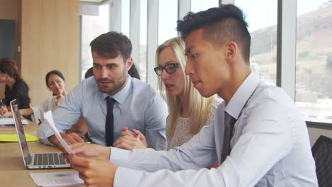 group of businesspeople meeting around table in boardroom