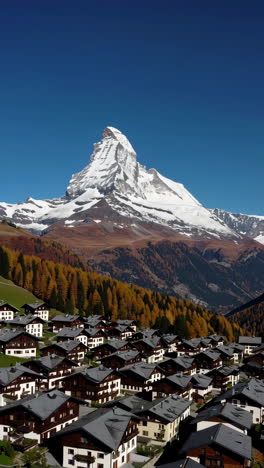 the iconic matterhorn mountain overlooking a swiss village with autumn foliage