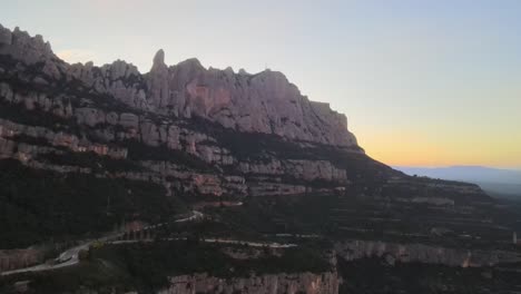 Aerial-views-of-Montserrat-peaks,-a-mountain-range-in-Catalonia-during-the-sunset