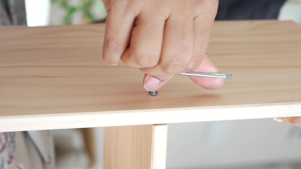 Person Assembling Wooden Furniture Using Allen Key