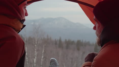 couple talking in tent on top of mountain