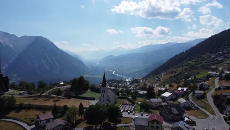 amazing church in front of a stunning mountain landscape, valley scenery in valais in switzerland, perfect sunny weather