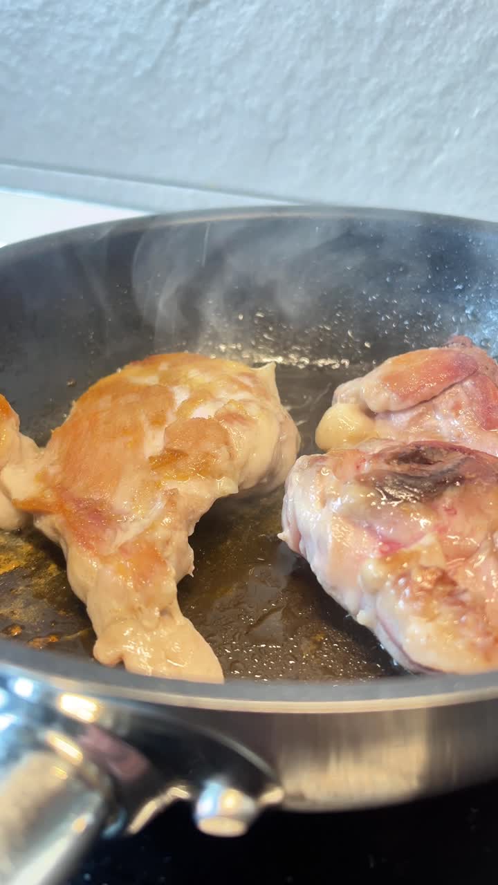 Della carne sta cuocendo in una padella. La carne si sta rosolando ed è ben cotta