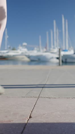 a person roller skating by a marina with yachts