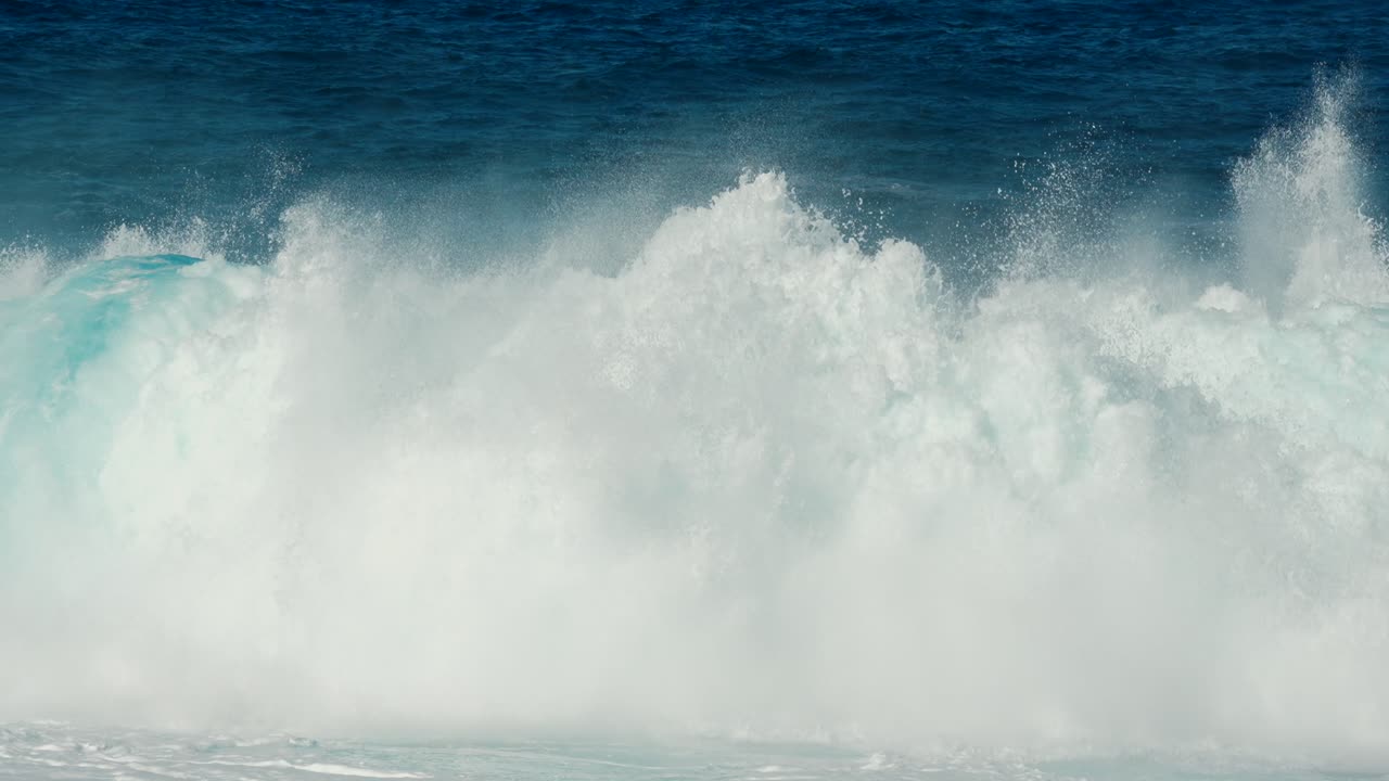 4K kinematisk sakte film av en turkis bølge som bryter og slår inn