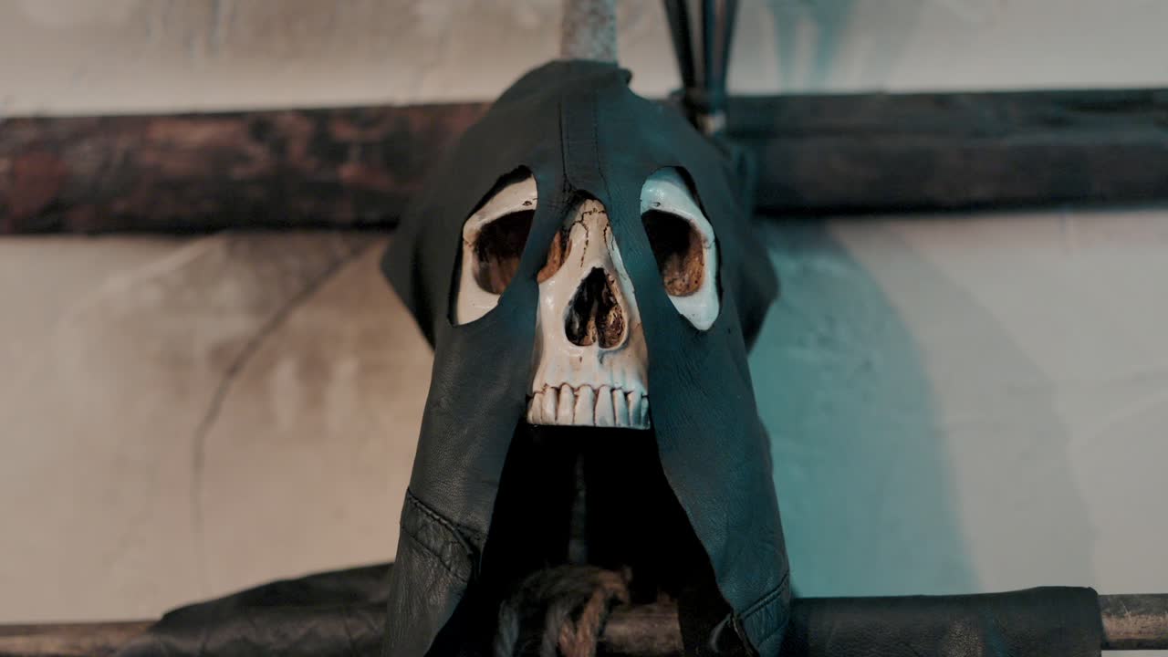 Skull in dark hooded cloak, rustic background creates eerie ambiance